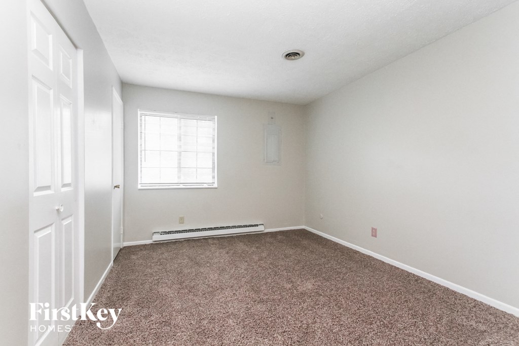 a bedroom with a carpeted floor and a window