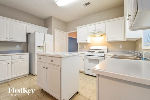 a large kitchen with white cabinets and white appliances