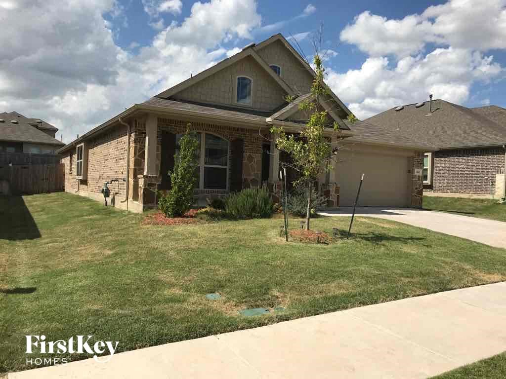 a house with a lawn and a driveway in front of it