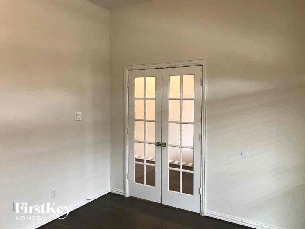 the living room of a house with white walls and doors