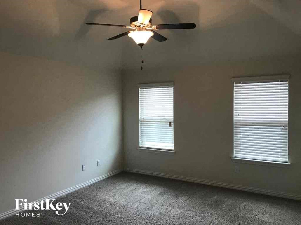 a bedroom with a ceiling fan and a window