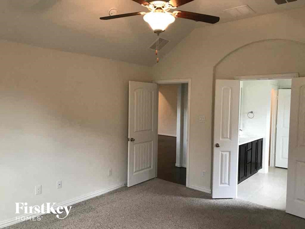 an empty living room with a ceiling fan