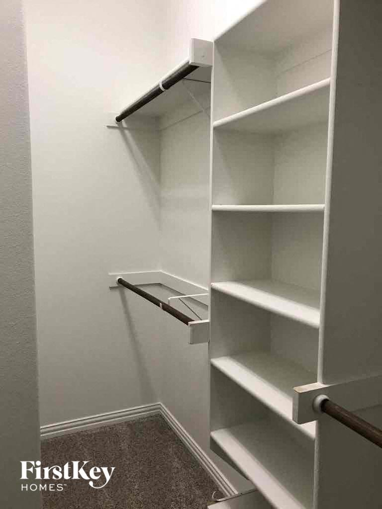a walk in closet with empty shelves in it