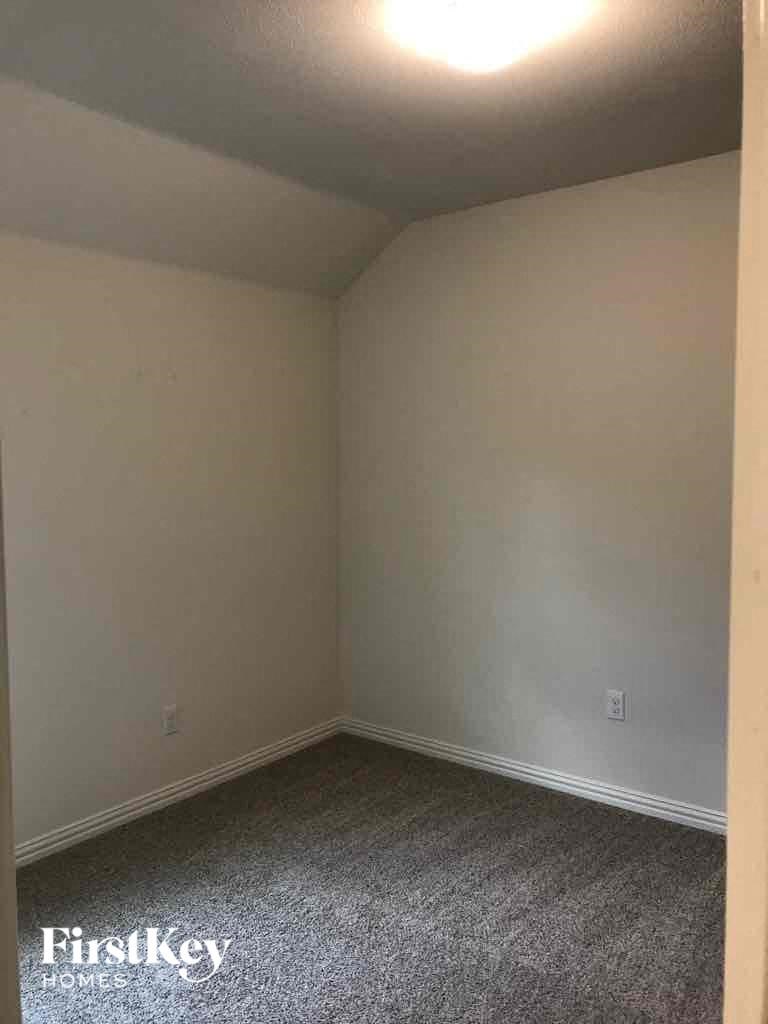 a small room with white walls and grey carpet