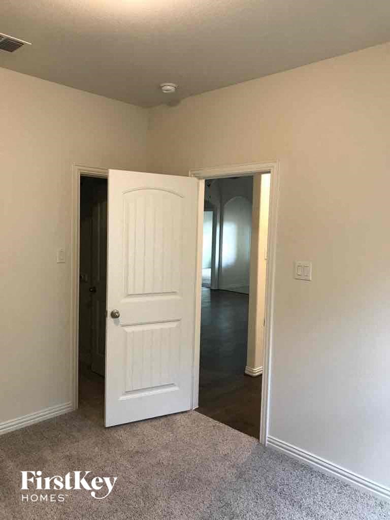 a room with a white door and a hallway with a door open