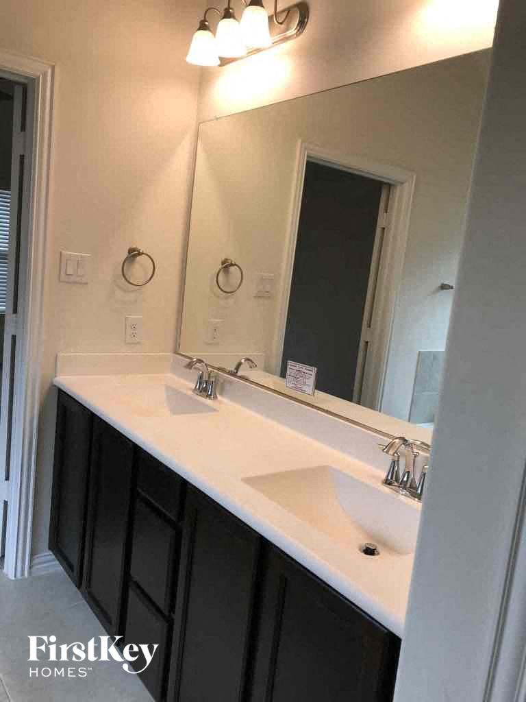 a bathroom with two sinks and a large mirror
