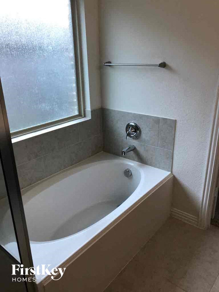 a small bathroom with a tub and a window