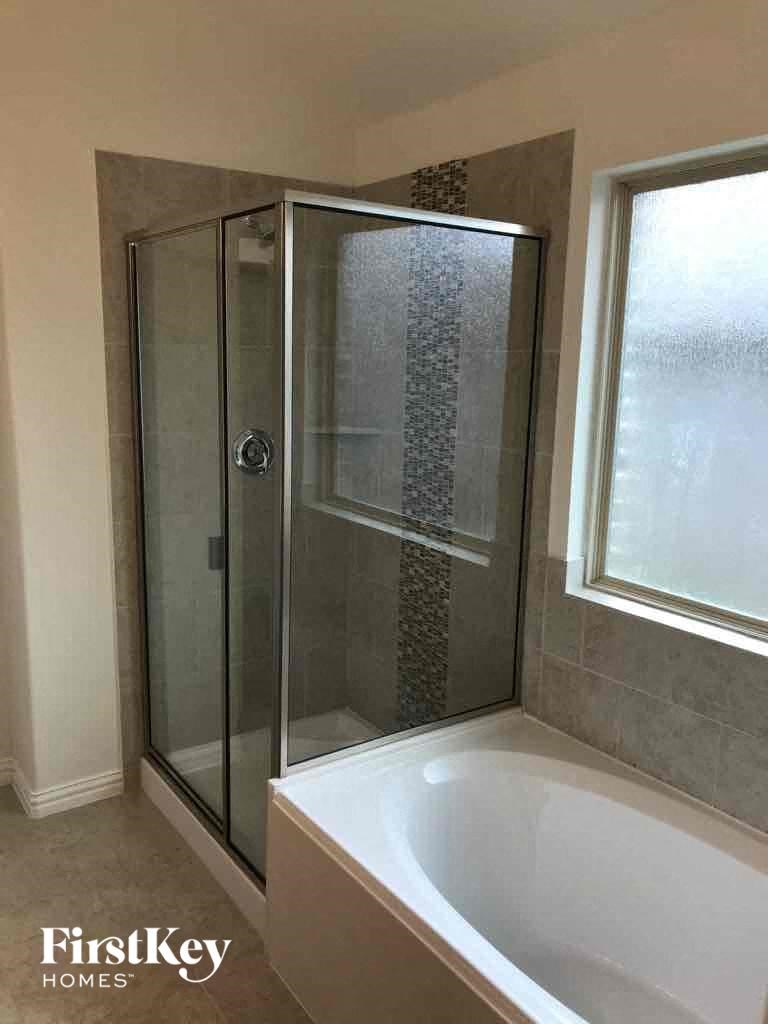 a small bathroom with a shower and a bath tub