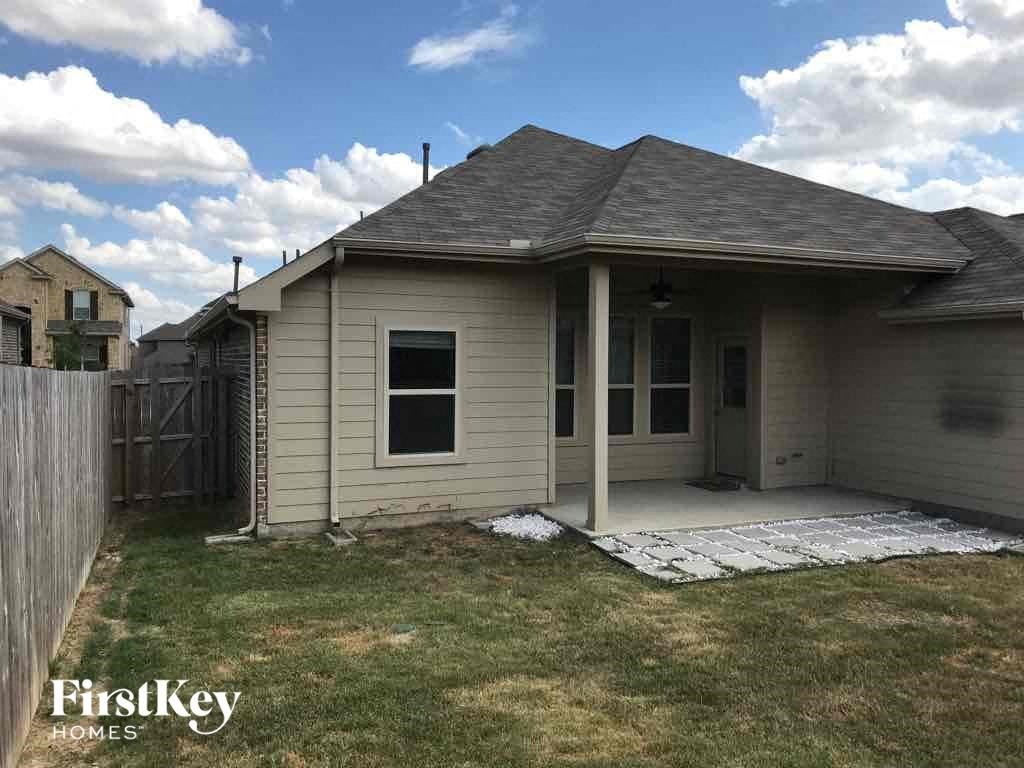 the front of a house with a yard and a fence