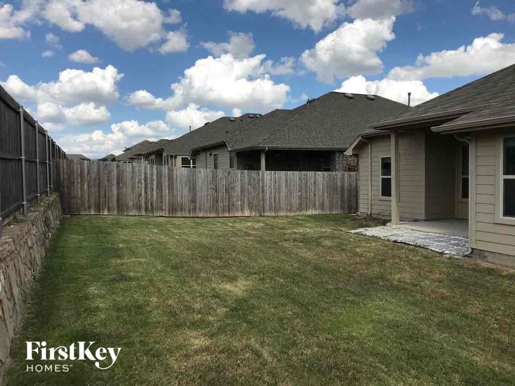 a backyard with a wooden fence and a grass yard