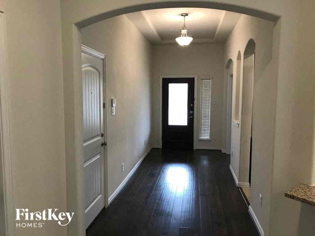a hallway with a dark wood floor and a door