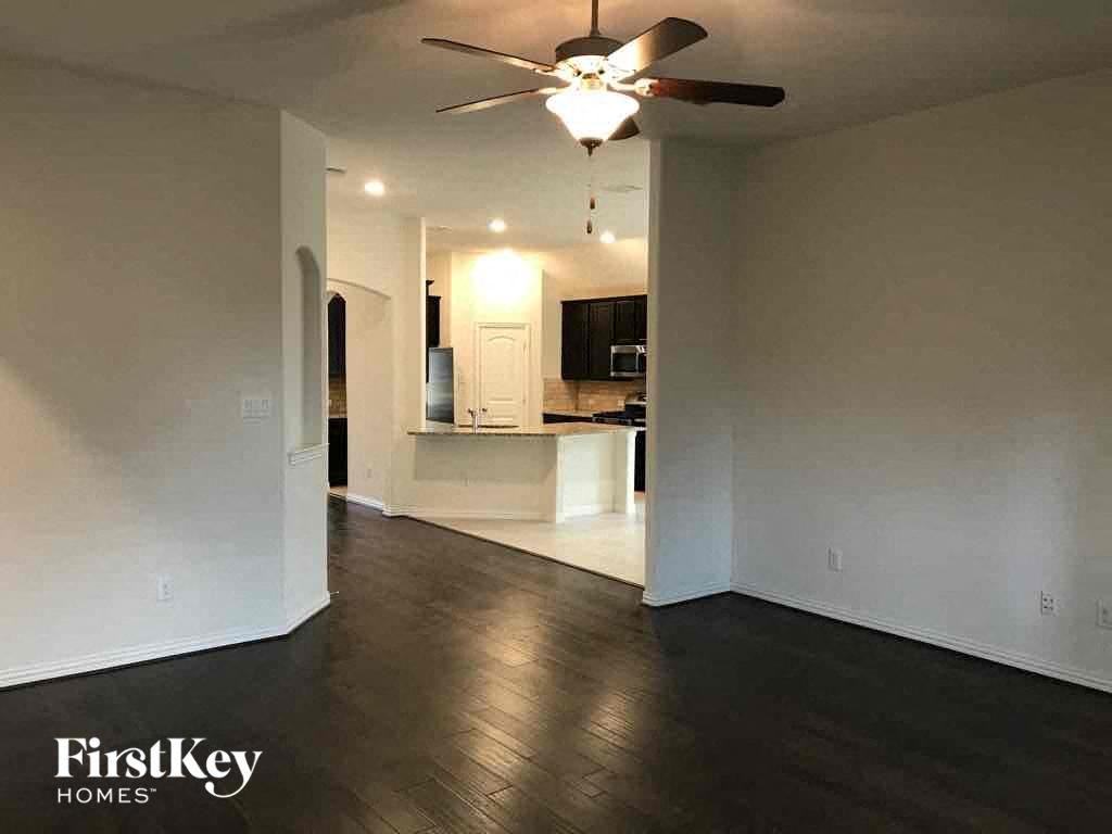 an empty living room with a ceiling fan