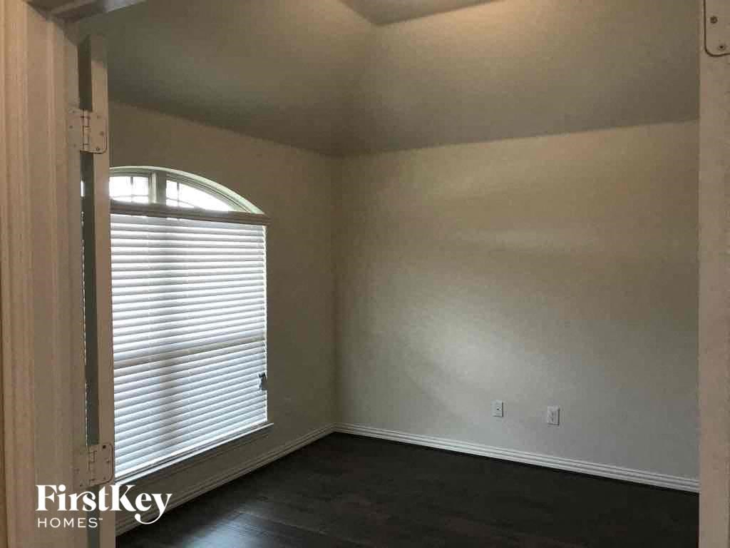 an empty living room with a window and a dark floor