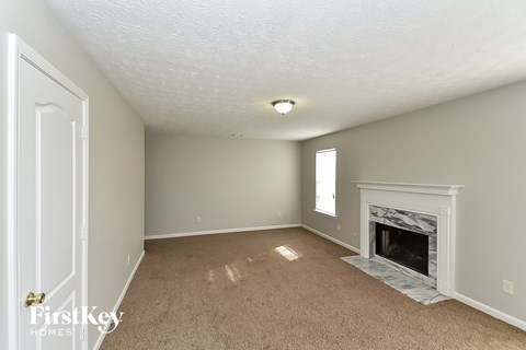 a living room with a fireplace and a carpeted floor