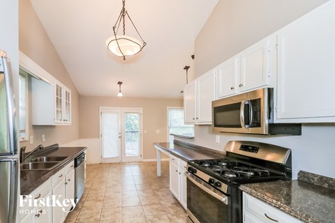 A kitchen with a stove top oven and a microwave above it.
