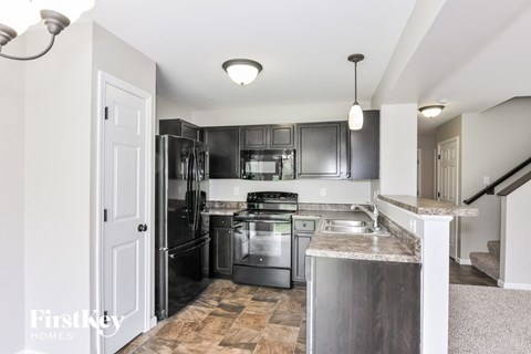 A kitchen with a stainless steel refrigerator, oven, and sink.