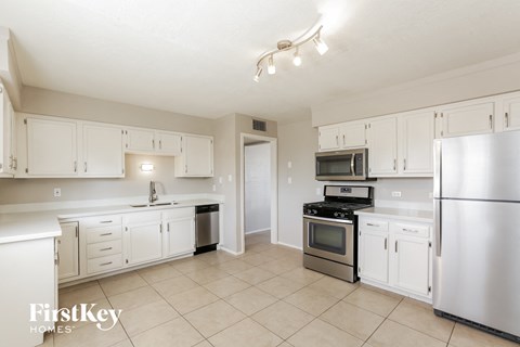 A kitchen with white cabinets and appliances.