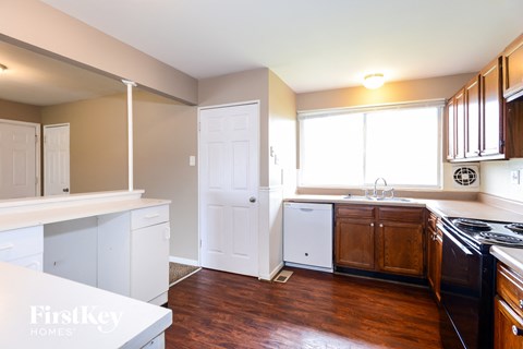 a kitchen with white cabinets and a stove and a window