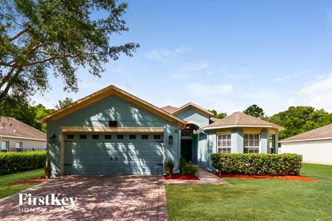 a house with a green garage door in front of a lawn