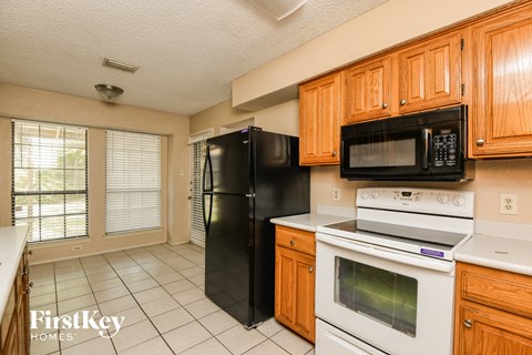 A kitchen with wooden cabinets and black appliances.