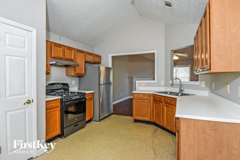 A kitchen with wooden cabinets and a stove top oven.