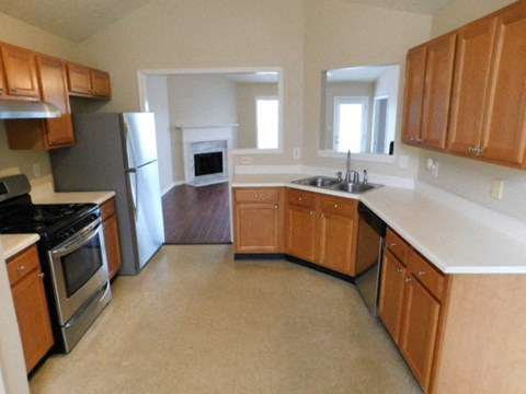 A kitchen with wooden cabinets and a white countertop.