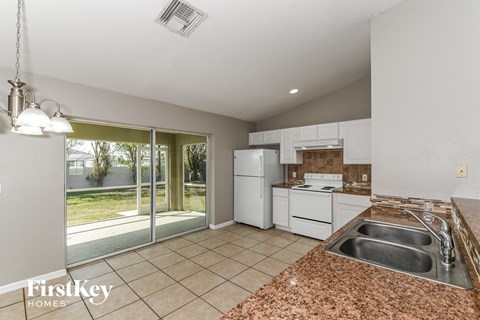 a kitchen with white appliances and a sink and a window