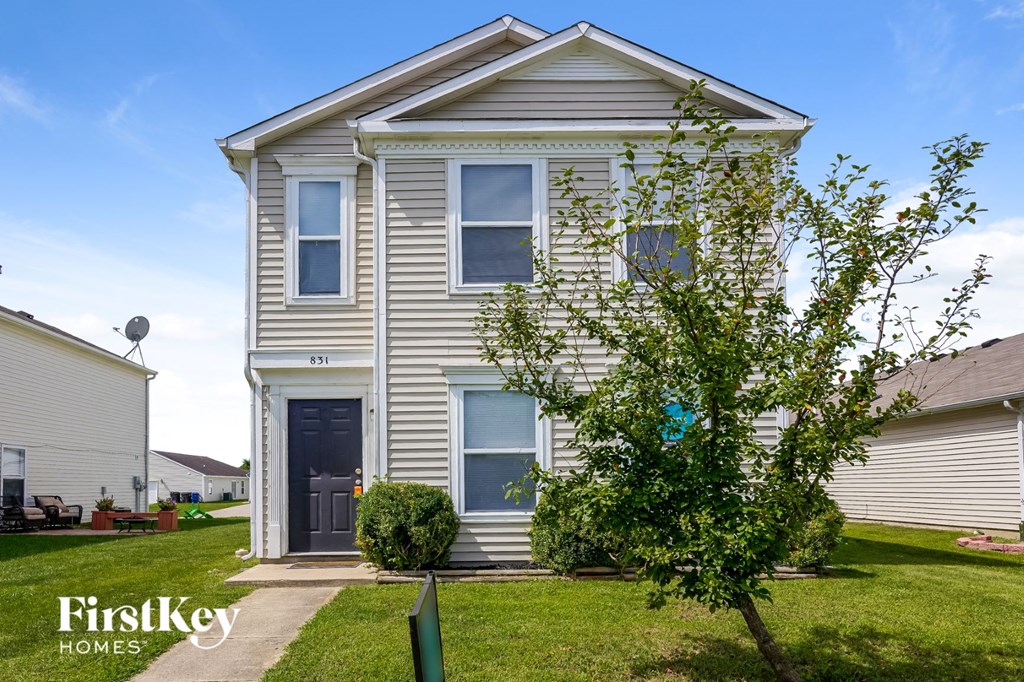 A two-story house with a grey facade and a black door.