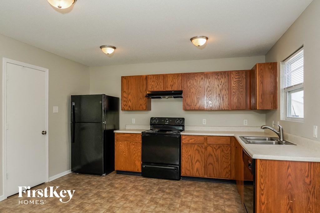 A kitchen with wooden cabinets and black appliances.