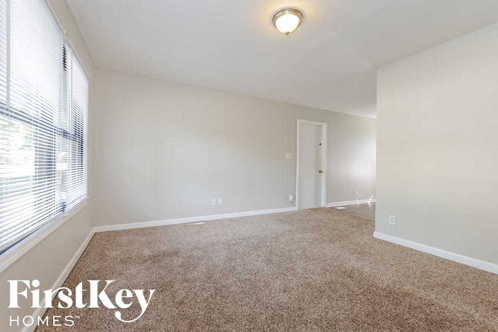 a bedroom with a carpeted floor and a large window
