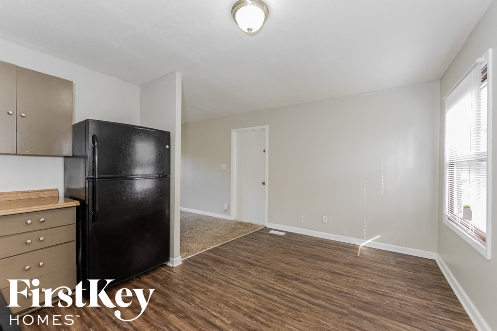 an empty kitchen with a refrigerator and a window