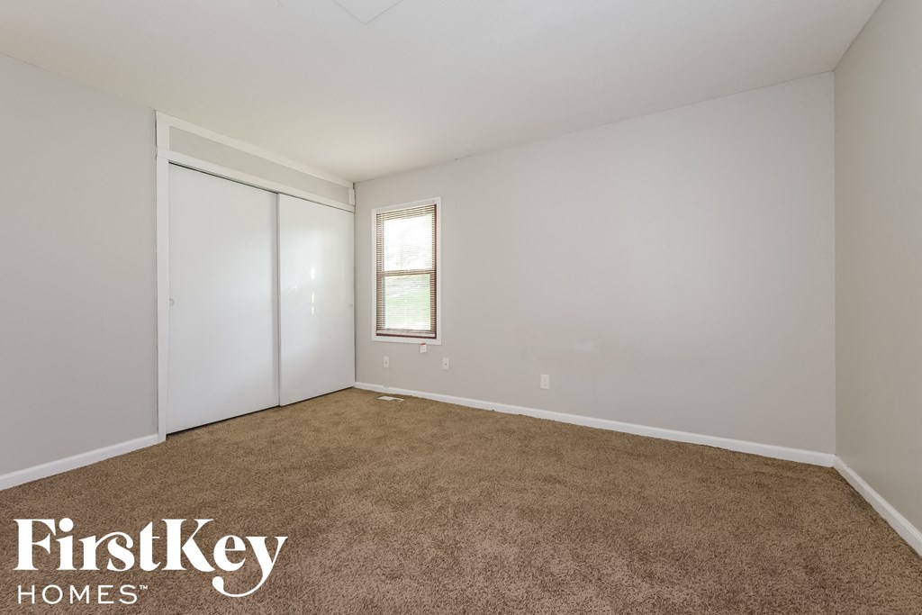 a room with carpet and a door to a closet