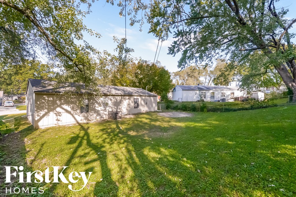 a backyard with a shed and a yard and a tree