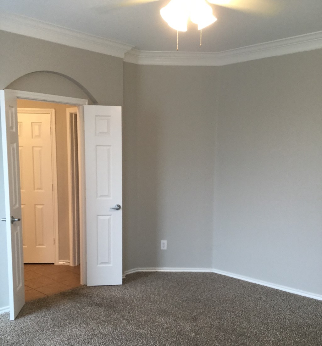 a room with a carpeted floor and a white door