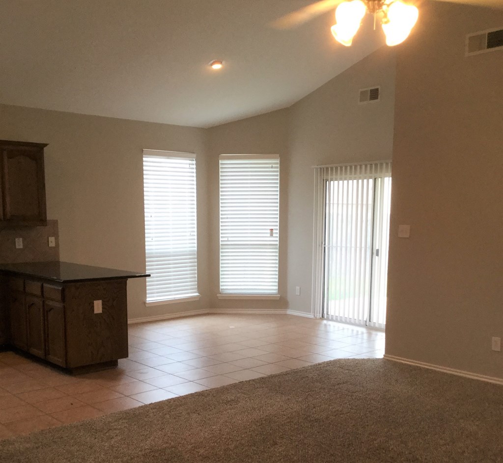 an empty living room with windows and a door