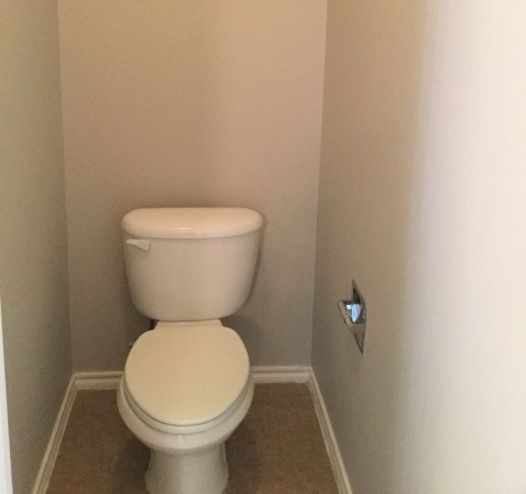 a small bathroom with a toilet and a paper dispenser