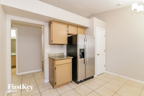 A kitchen with a black fridge and a black stove top oven.