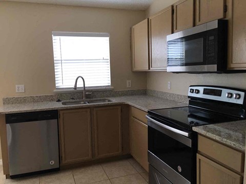 A kitchen with a black stove top oven and a black dishwasher.
