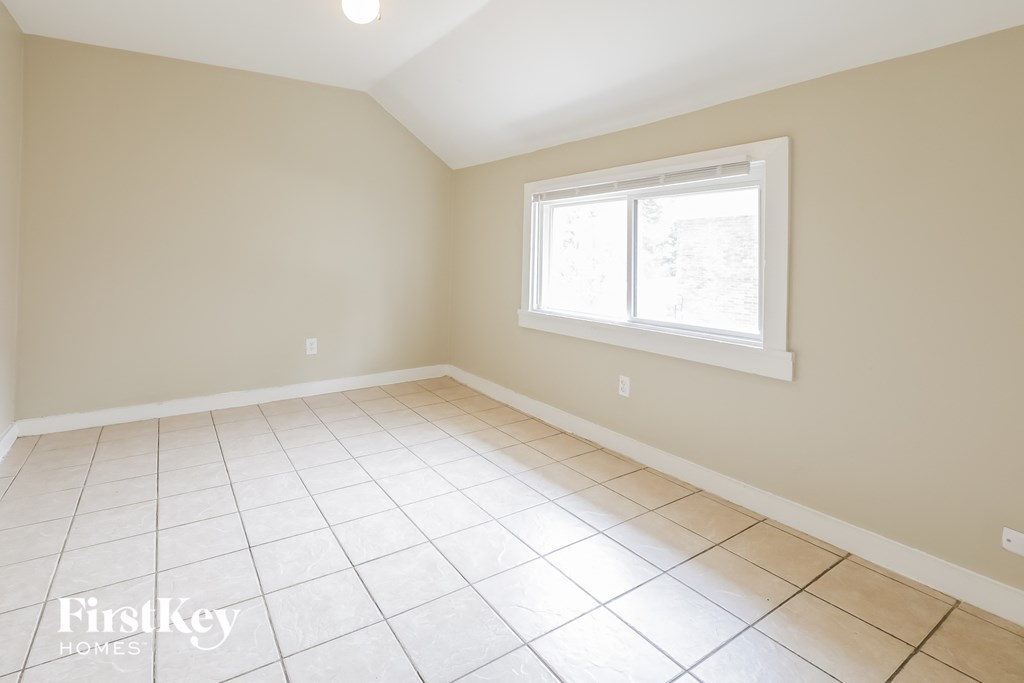 an empty room with a window and a tiled floor