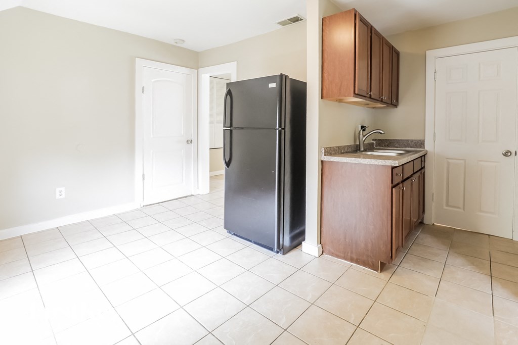 an empty kitchen with a refrigerator and a sink