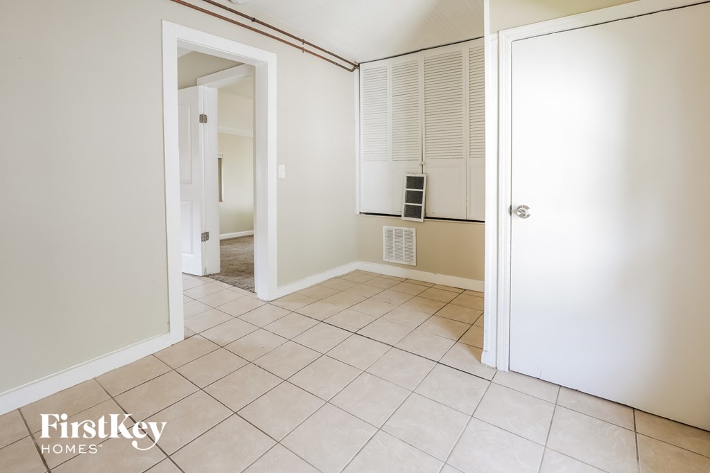 the living room and dining room of an empty home with a tiled floor