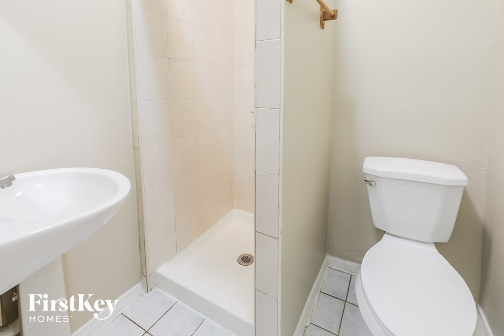 a bathroom with a shower and a toilet and a sink