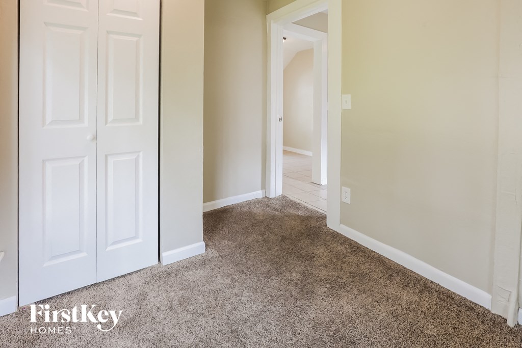 a bedroom with a carpeted floor and white closet doors