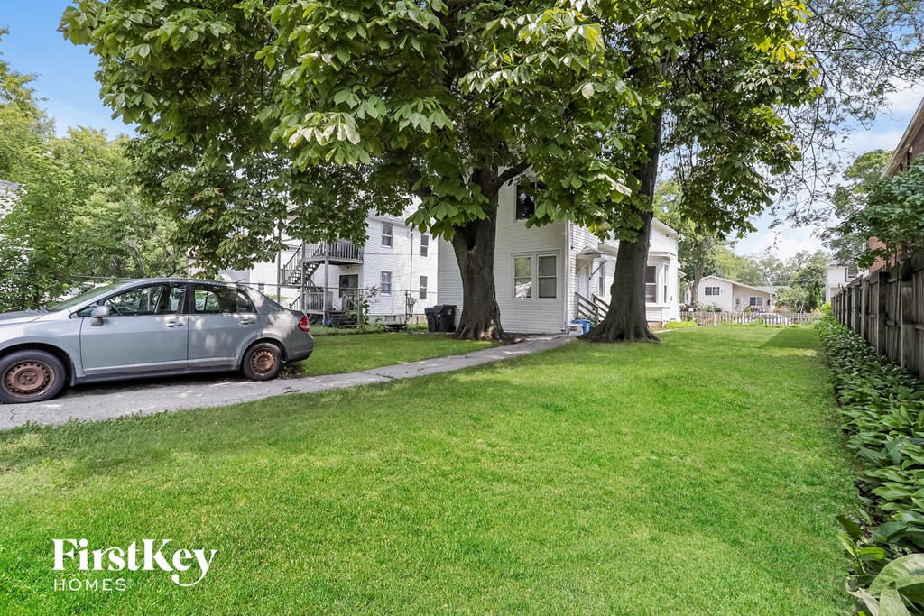 a car parked in the front yard of a white house