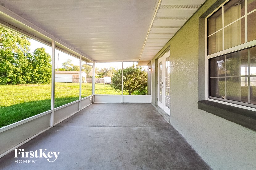 a porch with a view of the yard and grass