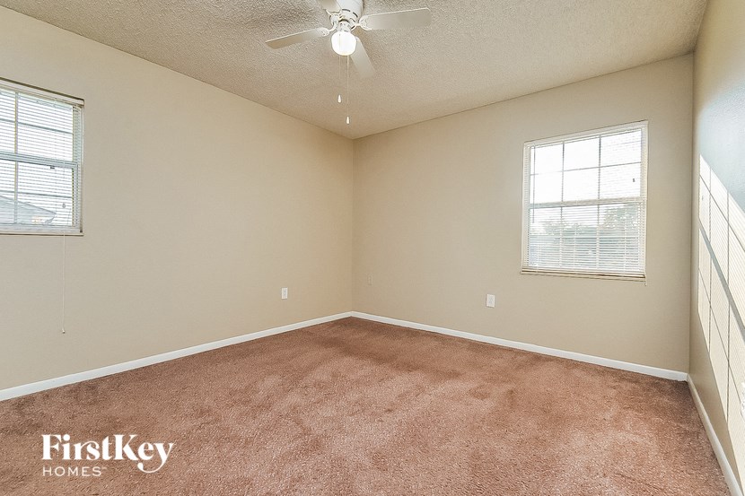 a bedroom with a carpeted floor and a ceiling fan
