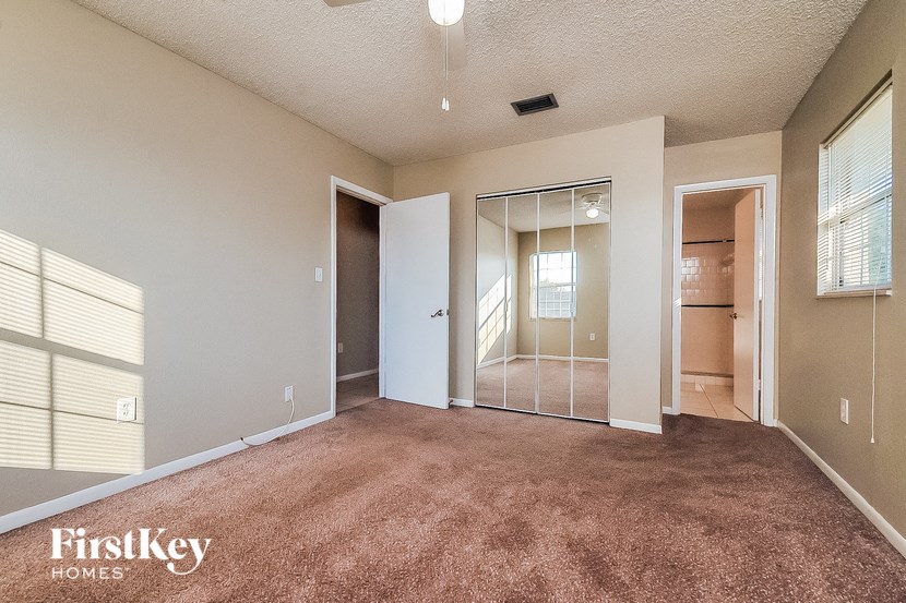 an empty living room with a mirrored closet