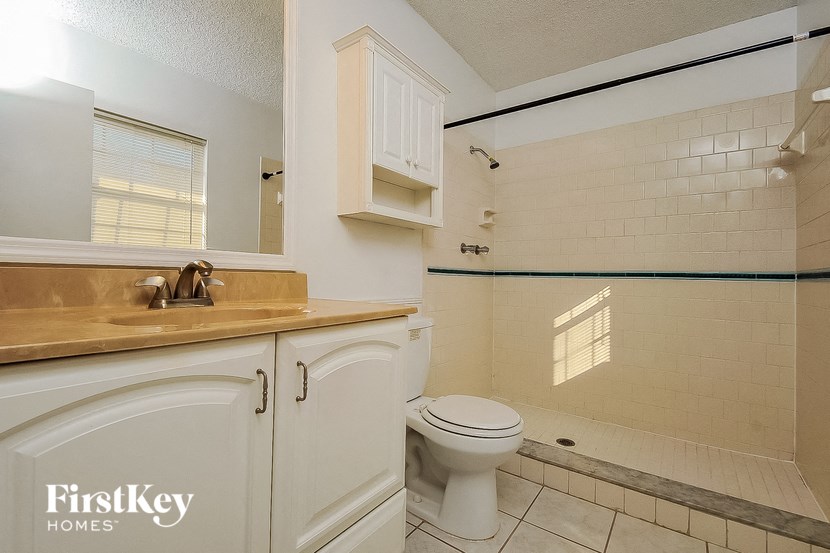 a bathroom with a toilet and a sink and a shower