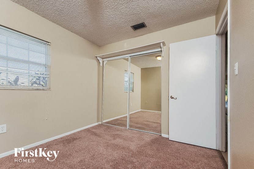 a bedroom with a door to a closet and a window