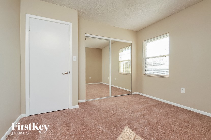 a bedroom with a mirror and a door to a closet